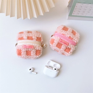 Detail of checkered plush earphone case with pearl zipper and cute embroidered tag
