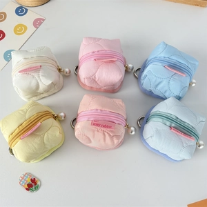 Macro detail of quilted flower earphone pouches in pastel colors with pearl pendants