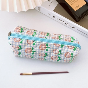Macro view of blue checkered quilted floral pouch with soft fabric and metal zipper detail