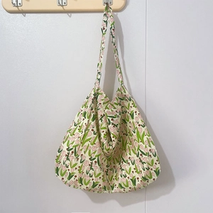 Close-up of beige floral cotton tote bag with tulip patterns and wide shoulder strap