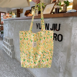 Détail du sac fourre-tout en toile à fleurs avec tulipes jaunes et écusson carré en tissu
