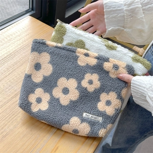 Detail of plush floral cosmetic bag with soft faux shearling texture and zipper closure