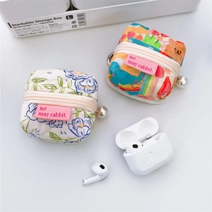 Detail of quilted floral and graffiti mini headphone cases with decorative pearl charms