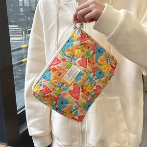 Detailed view of quilted makeup bag with colorful bear, heart, and flower patterns