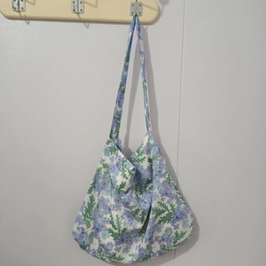 Close-up of floral print cotton tote bag with purple blossoms and green leaves