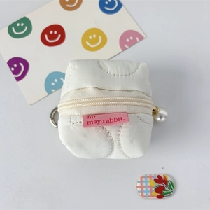 Detailed view of white quilted headphone case with pearl pendant and metal clasp hook