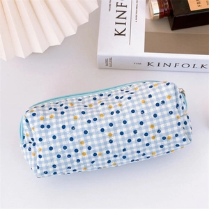 Quilted floral pencil case with blue checkered pattern and zipper on white desk