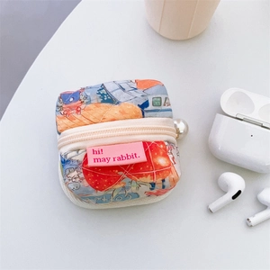 Quilted fabric headphone case with strawberry prints and pearl zipper detail on white table