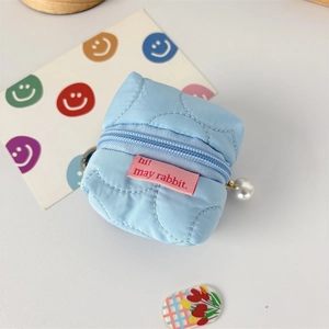 Close-up of light blue quilted mini earphone pouch with large pearl zipper charm detail