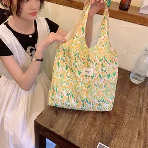 Vue détaillée du sac cabas en toile avec motif tulipes jaunes et étiquette de marque