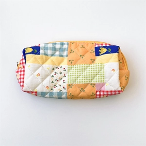 Close-up of vintage floral patchwork quilted bag with vibrant patterns and yellow zipper