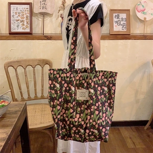 Détail du sac cabas en toile à fleurs avec motifs de tulipes et étiquette LOVE