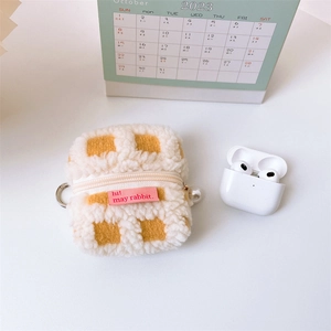 Detail showing waffle texture plush earphone case with golden zipper and large pearl accessory