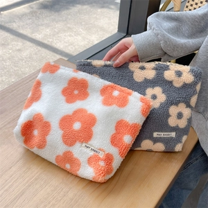 Detail of soft plush floral makeup bag with metal zipper and fluffy texture finish