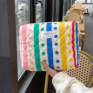 Close-up of quilted cotton makeup bag featuring colorful stripes and polka dot patterns
