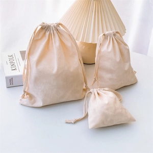 Three-piece set of beige cotton drawstring storage bags in various sizes with fabric texture