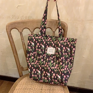 Détail du sac cabas en toile à fleurs avec imprimé tulipes et étiquette sur une chaise