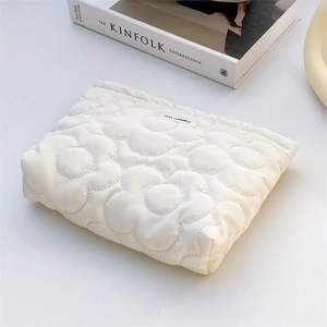 Detail of white quilted handbag with floral texture and Hay Rabbit brand label