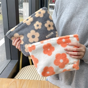 Detailed close-up of grey and white plush floral pouch showing soft shearling texture