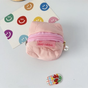 Close-up of pink quilted earphone pouch with heart stitching and pearl zipper pull