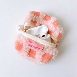 Close-up of pink waffle texture earphone pouch with a large pearl zipper charm