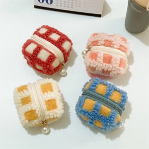 Close-up of colorful waffle plush mini pouches with pearl zipper detail in four grid patterns