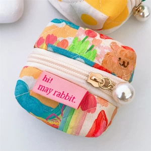 Detailed macro of a quilted fabric mini pouch with colorful bear and tulip prints
