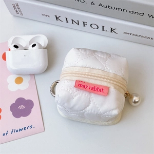 Détail d'étui pour écouteurs matelassé blanc en forme de cœur avec pendentif en perles