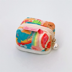 Close-up of quilted fabric mini pouch featuring bear prints and pearl zipper charm