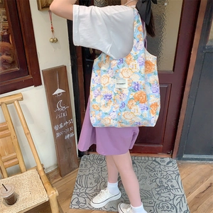 Détail du sac cabas en toile fleurie avec étiquette May Rabbit dans une rue