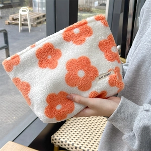 Detail of soft fleece makeup bag with floral pattern and brand woven label