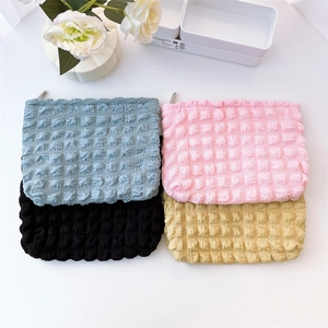 Close-up of bubble textured cosmetic bags in blue, pink, black and yellow colors