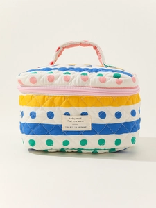 Detail of quilted cotton cosmetic bag featuring colorful polka dots and striped pattern