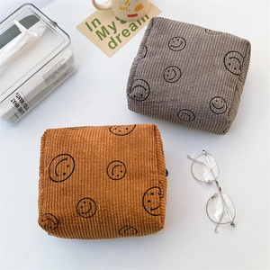 Macro shot of corduroy fabric texture and cute smiley patterns on makeup bags