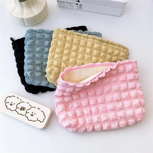 Detail of colorful bubble textured cosmetic bags with zip closure in various soft pastel colors