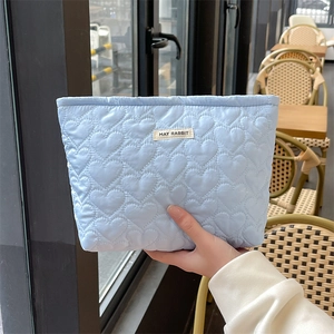 Light blue quilted heart makeup bag with May Rabbit label shown in a lifestyle setting