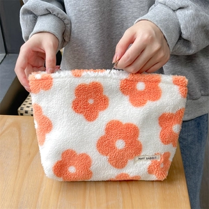Plush floral makeup bag in white lamb wool with orange flowers and zipper closure
