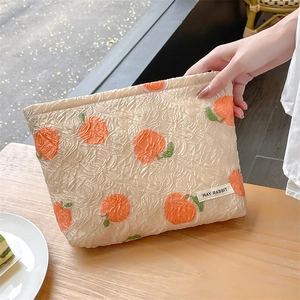 Off-white embossed floral clutch bag with bright orange persimmon pattern and zipper