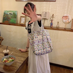 Vue détaillée du motif floral violet et de la toile épaisse sur ce grand sac cabas