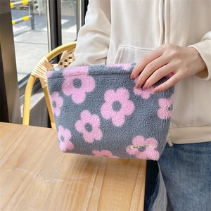 Detail of plush floral cosmetic bag with pink flower pattern and soft furry texture