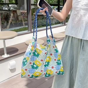 Dettaglio della borsa tote floreale con manici in corda blu e motivo a margherite