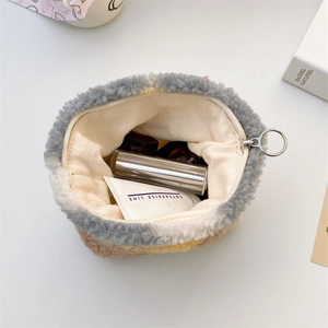 Macro detail of plush patchwork makeup bag with silver ring zipper and interior storage