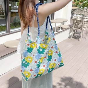 Dettaglio della borsa tote floreale con spalline in corda blu intrecciata e margherite