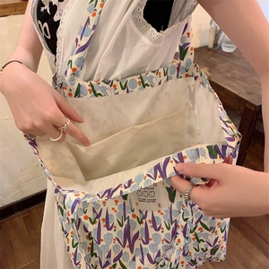 Détail du sac cabas en toile à fleurs montrant la poche intérieure et l'imprimé