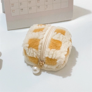 Macro shot of yellow checkered waffle plush storage pouch with decorative pearl zipper
