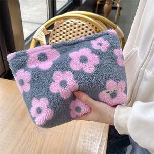 Detailed macro view of plush flower cosmetic bag with gray and pink floral patterns