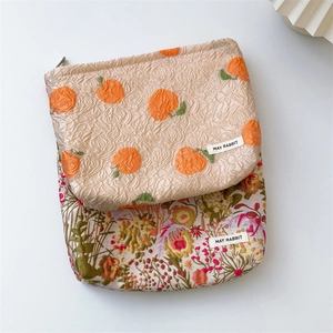 Detail of embossed jacquard cosmetic bags with citrus embroidery and floral patterns