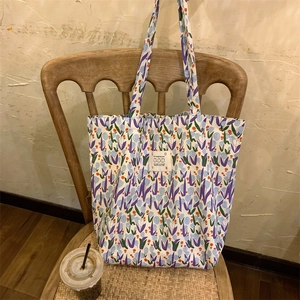 Détail du sac cabas en toile à fleurs avec tulipes mauves et étiquette tissée