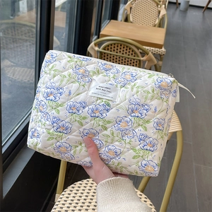 Close-up of quilted floral cotton fabric texture and sturdy zipper on the cosmetic bag