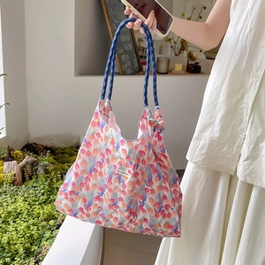 Dettaglio della borsa shopper floreale con motivi di tulipani e manici in corda blu